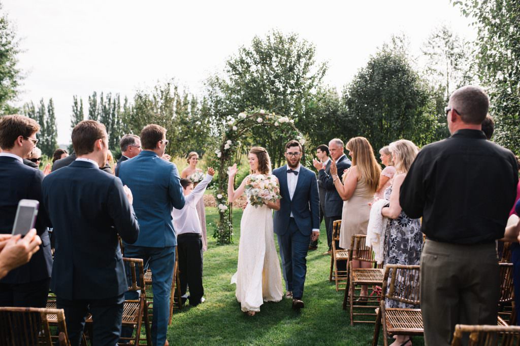 Zoe and Daniel walk down the aisle at their wedding at Zoe and Daniel share their first kiss as husband and wife at Woodinville Lavender Farm, Washington, summer 2016