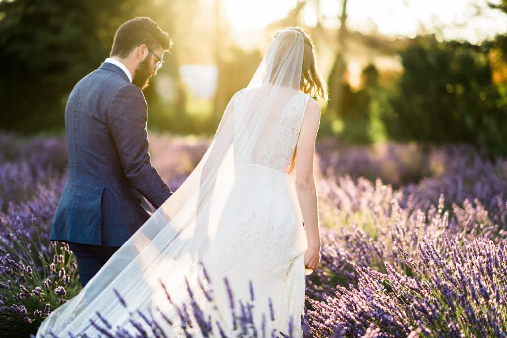 Zoe and Daniel walk through the lavender fields of Zoe and Daniel walk down the aisle at their wedding at Zoe and Daniel share their first kiss as husband and wife at Woodinville Lavender Farm, Washington, summer 2016