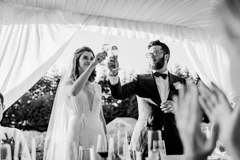 Zoe and Daniel toast to their guests at their wedding reception at Zoe tears up as her dad gives a toast at hers and Daniels' wedding reception at Champagne and guests at the Woodinville Lavender Farm, Washington, Summer 2016