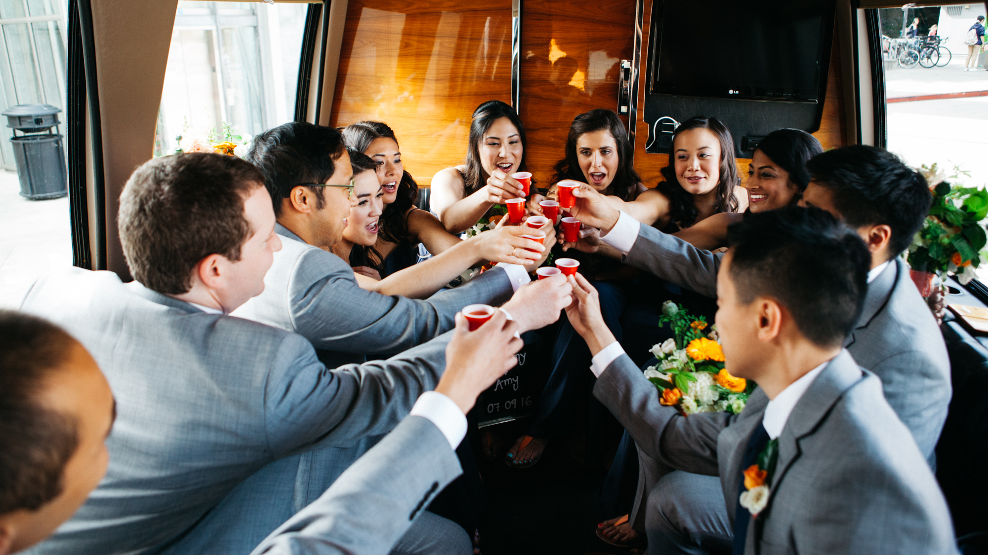 Bridesmaids and groomsmen toast the bride and groom as they take the stretch to Chihuly Garden and Glass