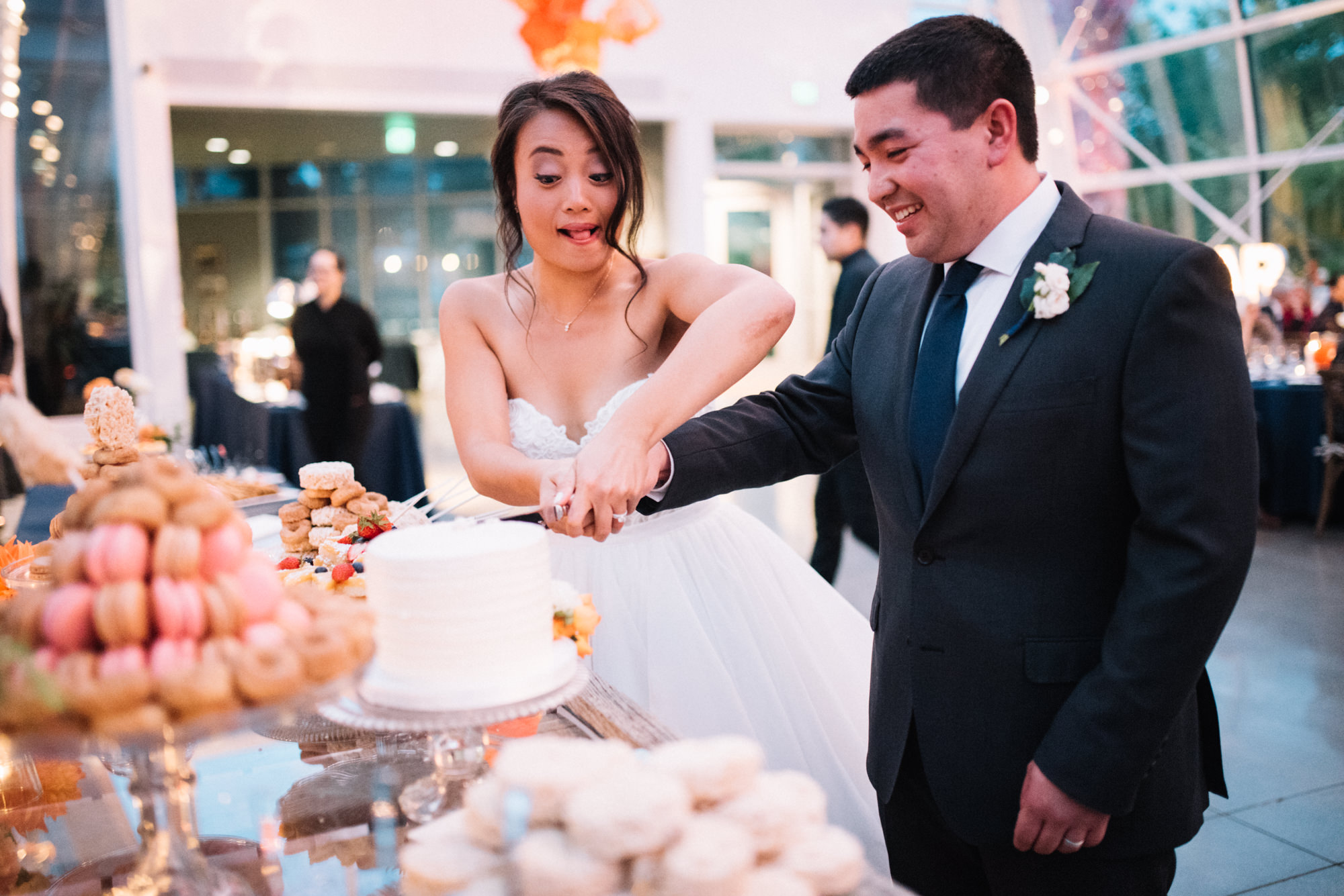 Amy and Jeremy cut their wedding cake at their wedding reception at Chihuly Garden and Glass