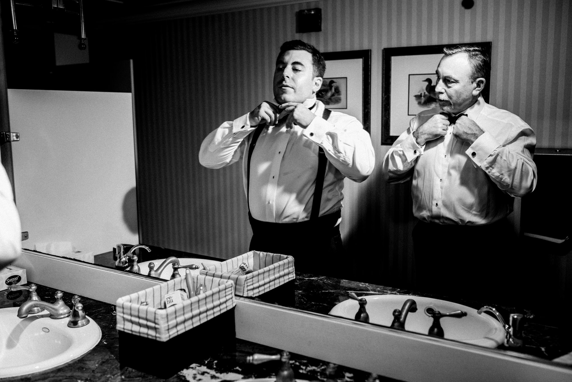 Ryan and his dad tie their bowties while getting ready at the Seattle Tennis Club for Ryan's wedding. Summer 2016. Photo by Seattle Wedding Photographers Jennifer Tai Photo Artistry.