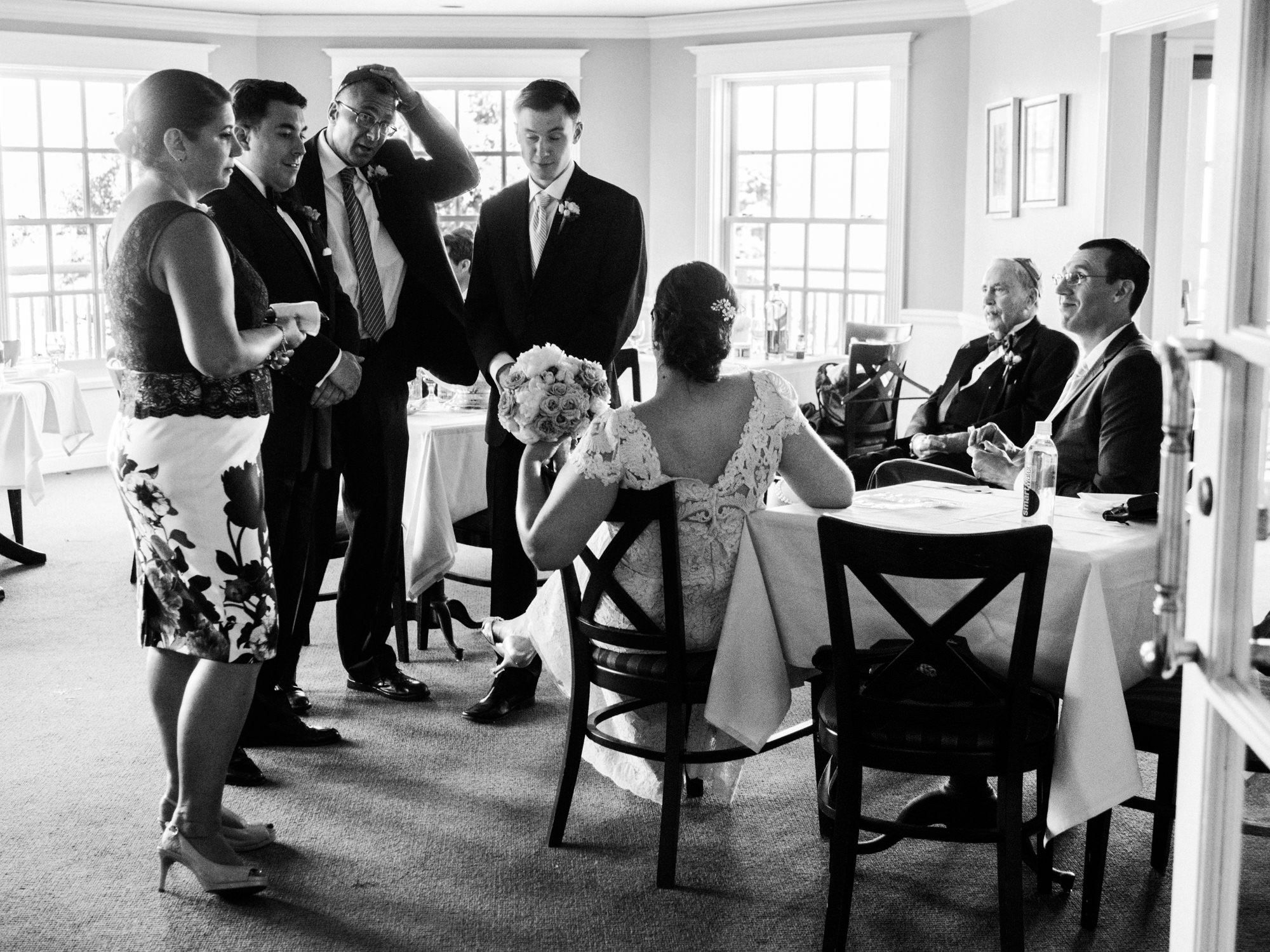 Joelle, Ryan and their wedding party take a break before the wedding ceremony at the Seattle Tennis Club, a wedding venue in Seattle, WA. Summer 2016. Photo by Seattle Wedding Photographers Jennifer Tai Photo Artistry.