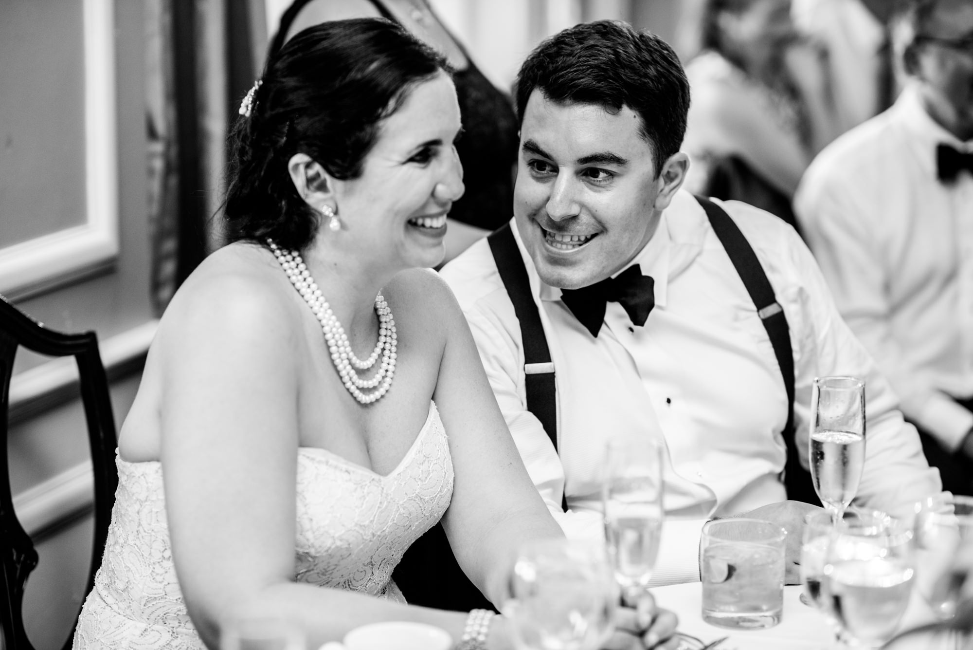 Ryan whispers "He NAILED it!" to Joelle regarding his younger brother's toast at their wedding reception at the Seattle Tennis Club, a wedding venue in Seattle, WA. Summer 2016. Photo by Seattle Wedding Photographers Jennifer Tai Photo Artistry.