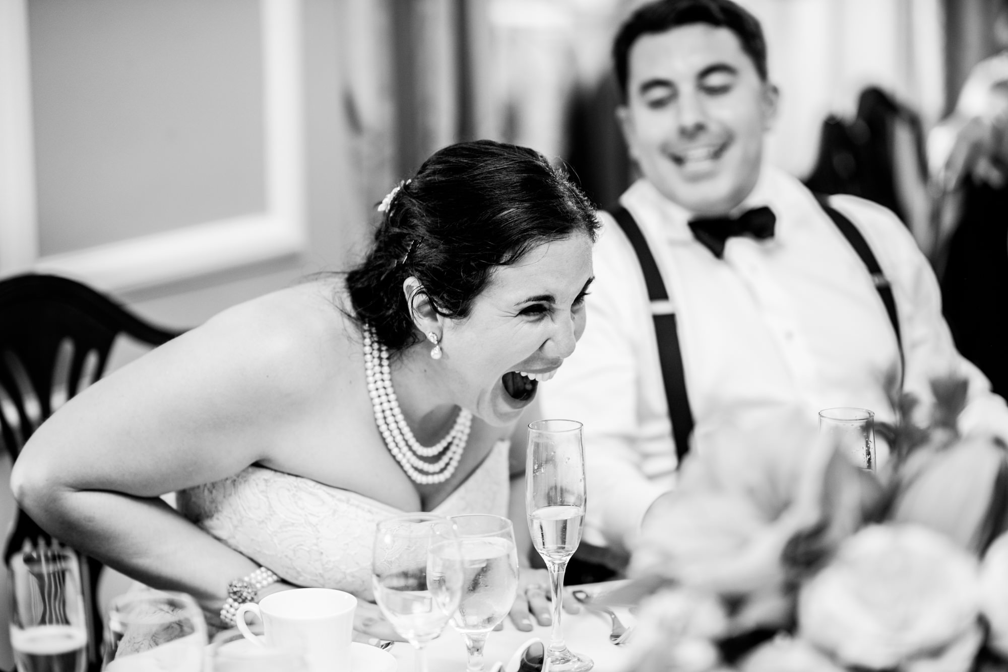 Joelle and Ryan laugh at a rap her sister and brother are doing for the newlyweds at Joelle and Ryan's wedding reception at the Seattle Tennis Club. Summer 2016. Photo by Seattle Wedding Photographers Jennifer Tai Photo Artistry.