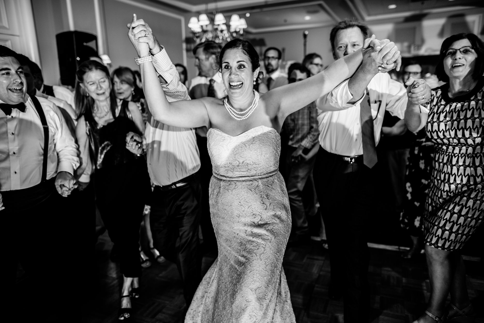 Joelle and guests begin the horah, a traditional Jewish wedding dance . Seattle Tennis Club, summer 2016. Photo by Seattle Wedding Photographers Jennifer Tai Photo Artistry.