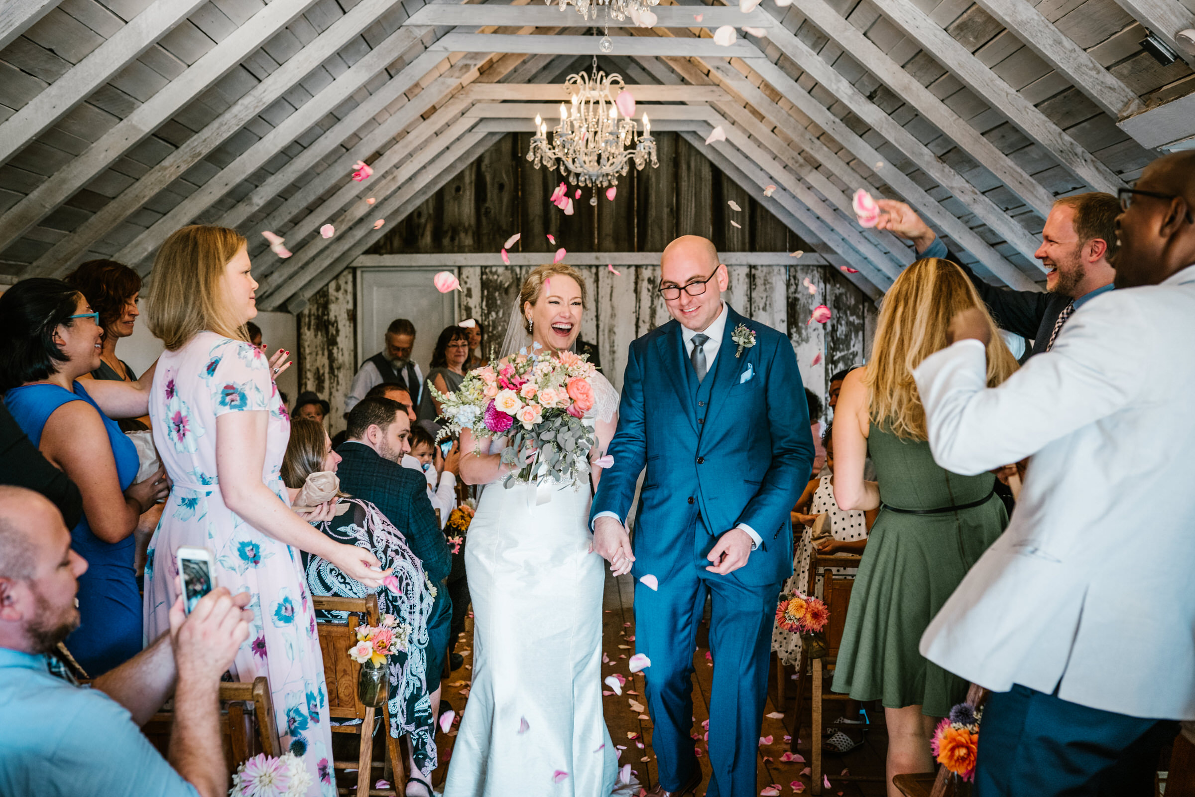 Wayfarer Whidbey Island Wedding: Sara and Joe walk down the aisle as guests throw rose petals