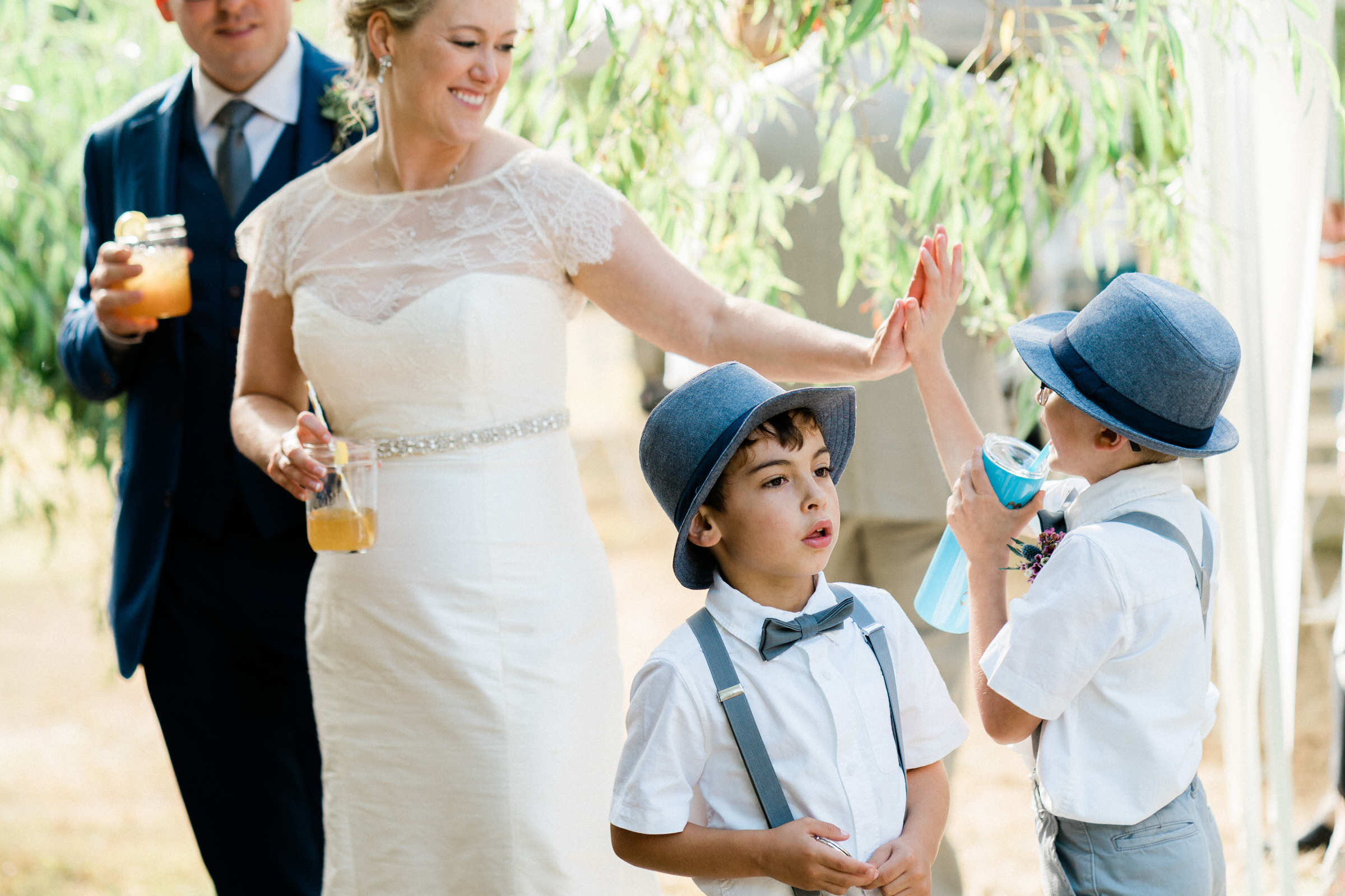 Wayfarer Whidbey Island Wedding: The bride high-fives one of the little groomsmen for a job well done