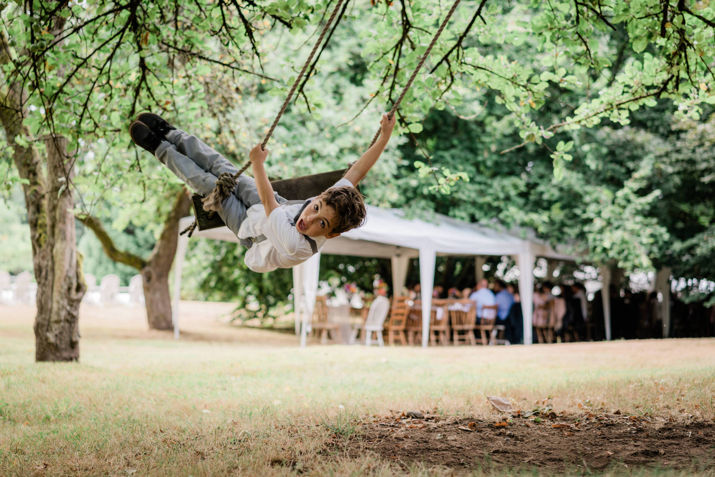 Wayfarer Whidbey Island Wedding: A wedding groomsmen swings from a nearby tree at the wedding