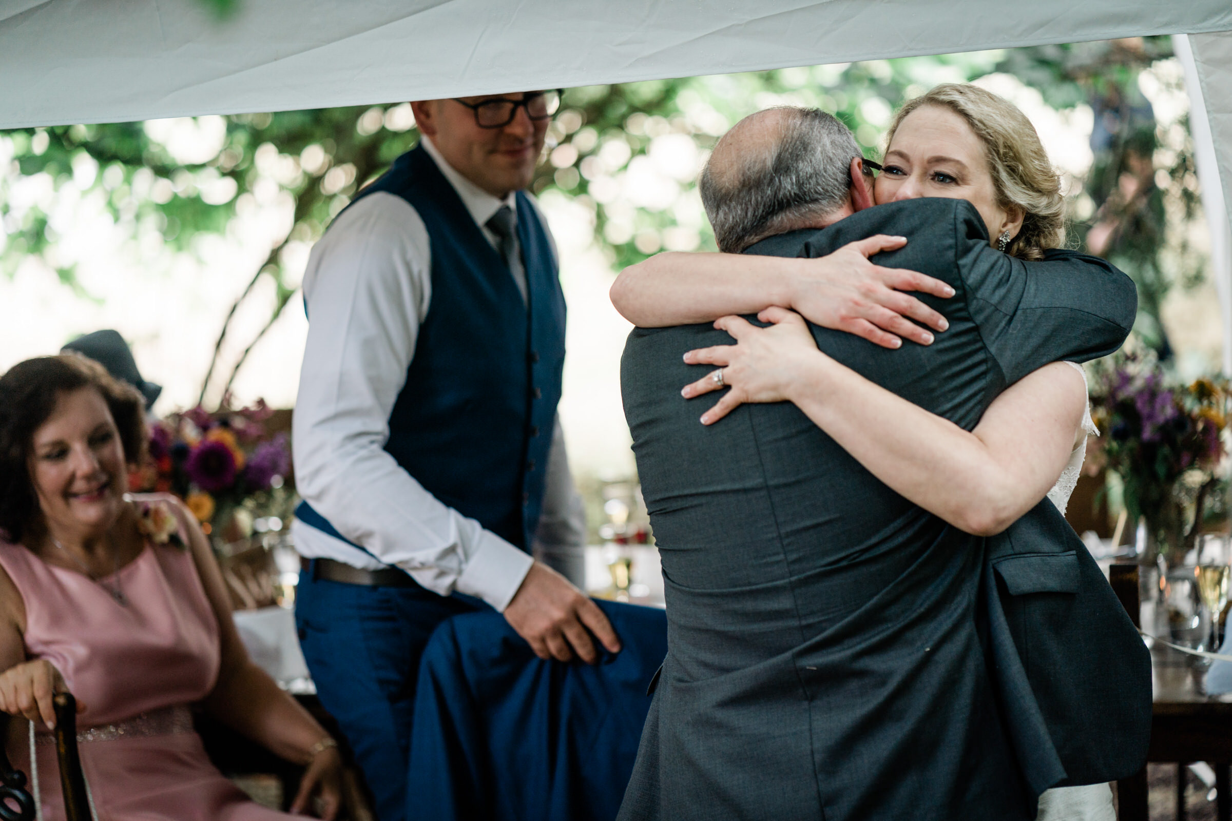 Wayfarer Whidbey Island Wedding: Joe's dad gives Sara a hug after his toast