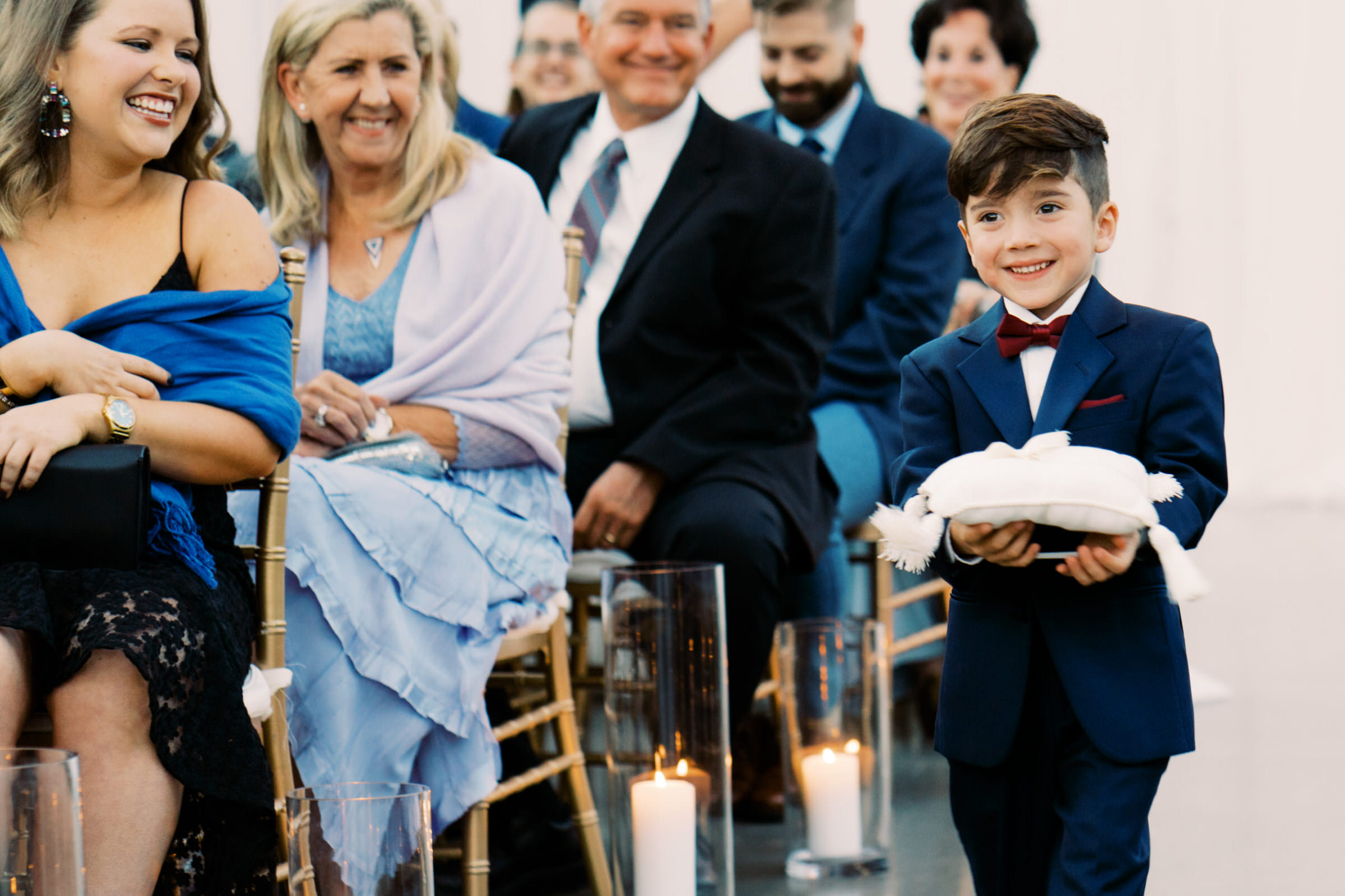 Adorable ringbearer walking down the aisle at Lauren and Kyles wedding
