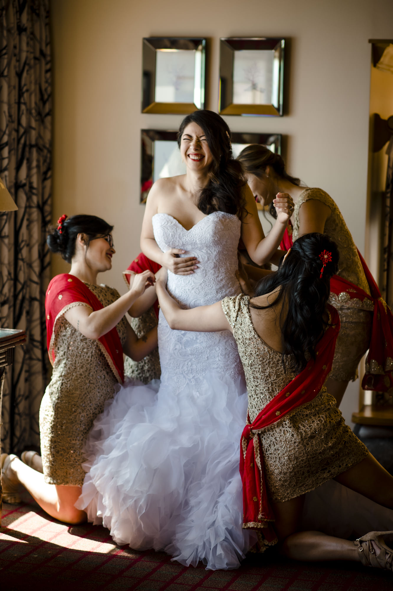 Bridesmaids helping Kelly into her wedding gown. Photo by Jenn Tai, Seattle wedding photographer.
