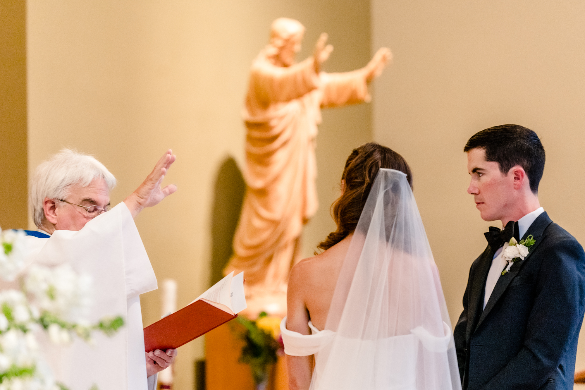 Wedding at Sacred Heart Church Seattle: Wedding at Sacred Heart Church Seattle: Priest blesses bride and groom