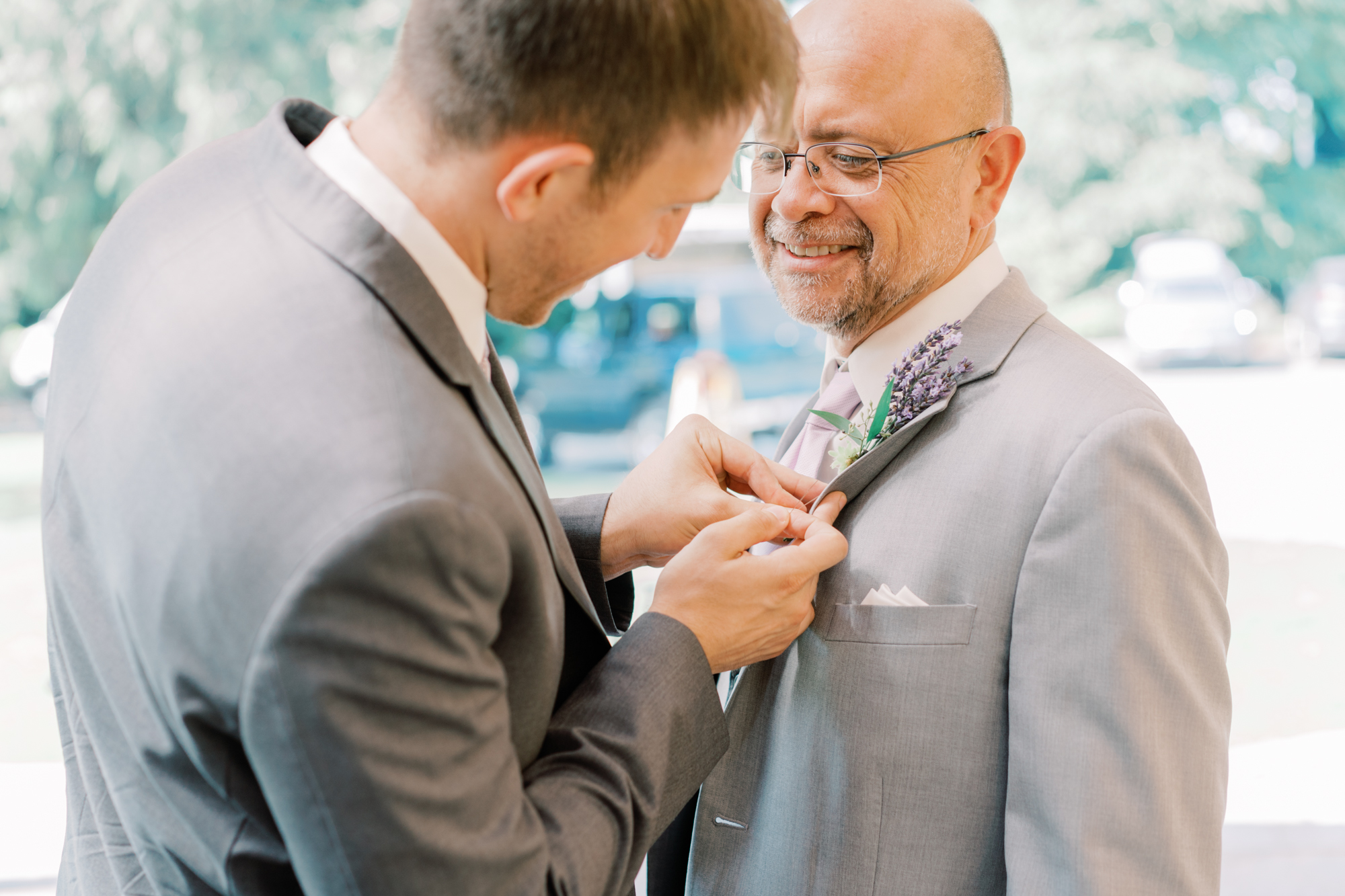Groom puts boutonniere on dad