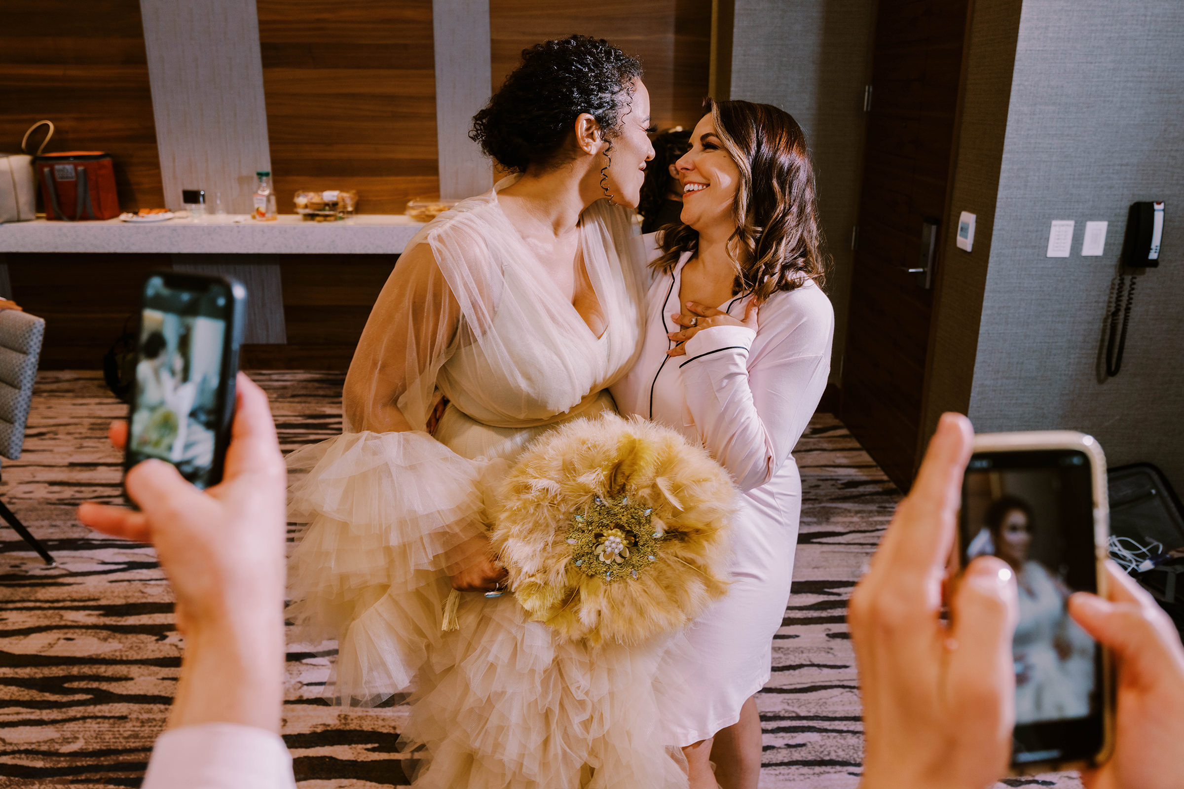Bride with her sister bridesmaid posing for a phone photo, Hyatt Regency Lake Washington wedding, summer 2022