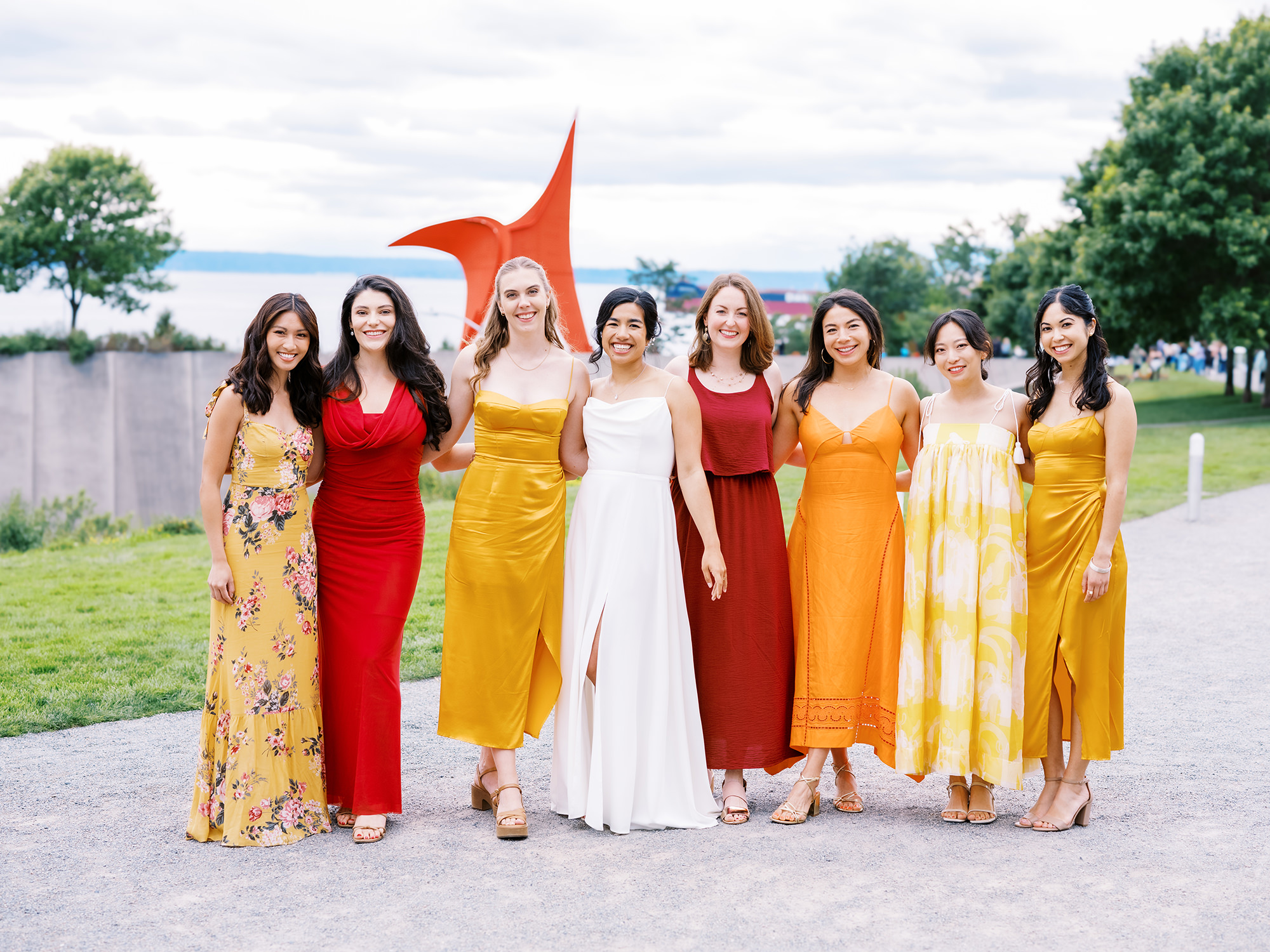 Bride Ananya with her bridesmaids in sunset color dresses