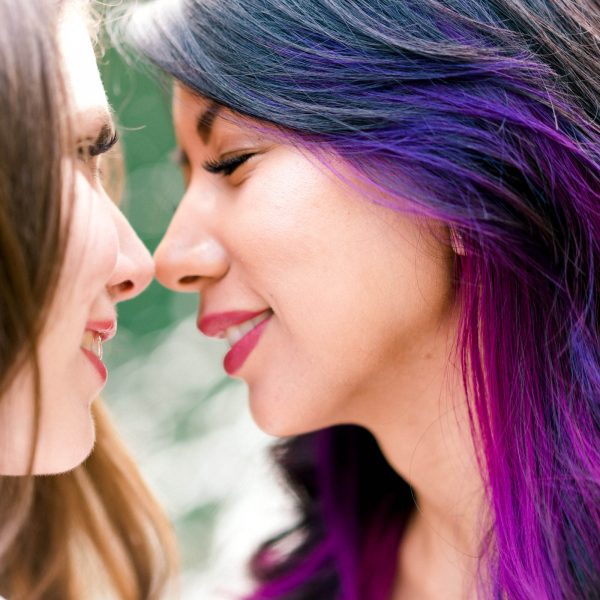 Two women smiling and about to kiss during an engagement photo session with Jenn Tai & Co - Seattle wedding photography